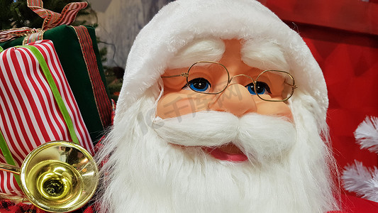 一个快乐的玩具娃娃圣诞老人带着一袋礼物的照片肖像象征着圣诞节和新年的到来。
