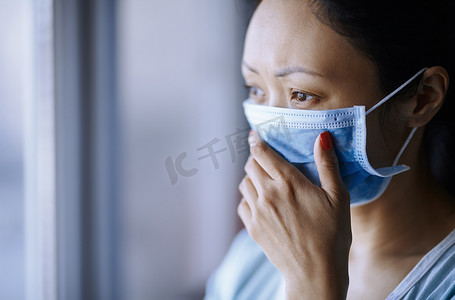 急性传染病摄影照片_戴着防护外科口罩呆在家里的妇女