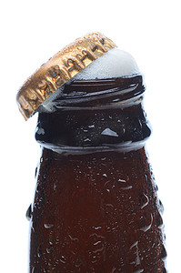 啤酒瓶啤酒盖摄影照片_特写泡沫啤酒瓶顶