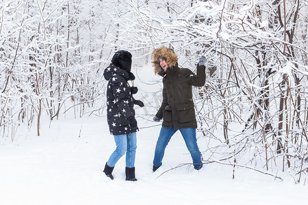 热恋中的年轻情侣在白雪皑皑的森林里玩得很开心。