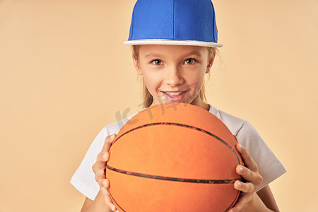 拿着篮球的运动帽的可爱女孩