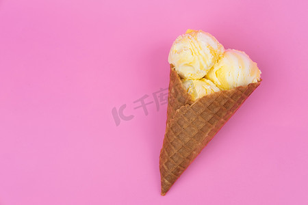 粉红色背景的华夫饼锥中的果香冰淇淋球。