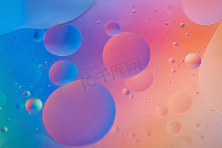 蓝色泡泡摄影照片_用油、水和肥皂制成的橙色和蓝色抽象背景图片