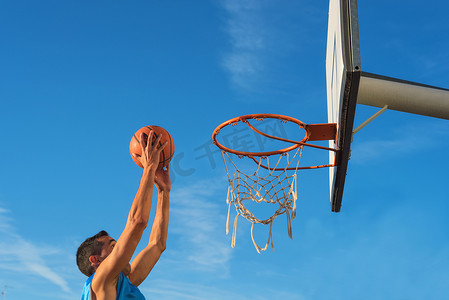 街头篮球运动员在球场上表演扣篮
