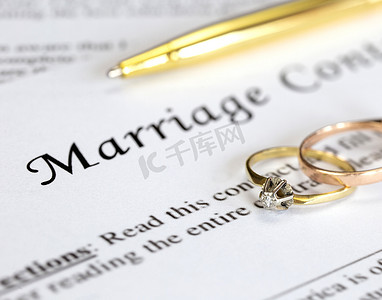 协议离婚摄影照片_与两个金婚戒指和金笔的婚姻合同、婚前协议、宏观特写、签字、文件、协议概念
