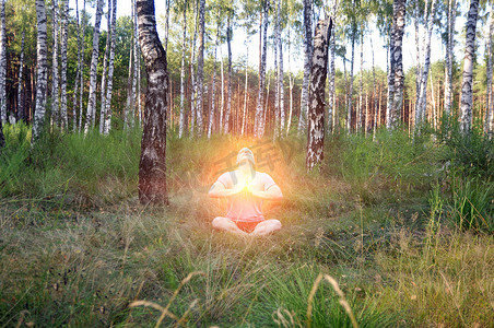 夏季白桦林中，一名年轻人以莲花坐冥想。