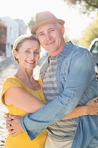 对着阳光摄影照片_快乐的成熟夫妇在城市里对着镜头微笑