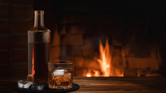 燃烧的壁炉附近的桌子上放着一瓶和一杯加冰的威士忌。
