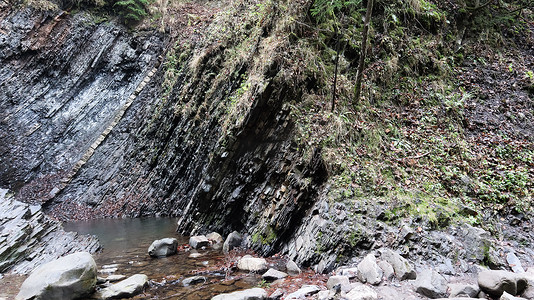 瀑布位于有石墙的小峡谷中。
