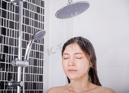 女人用雨淋洗头发和脸