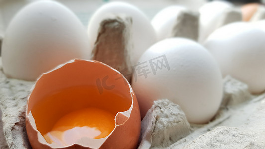 鸡蛋碎了摄影照片_在其他鸡蛋中，有一个鸡蛋已经破了一半。