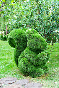 背景树中的绿色雕塑松鼠。