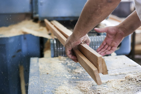 工匠们在希腊一家木工工厂切割一块木头