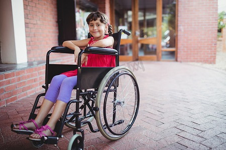 轮椅残疾人摄影照片_坐在轮椅上微笑的女孩