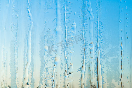 结霜的窗玻璃上的冰花和霜图案