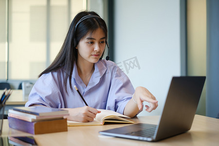 一名女孩在网上上课前通过笔记本电脑上的视频练习基础课程练习。