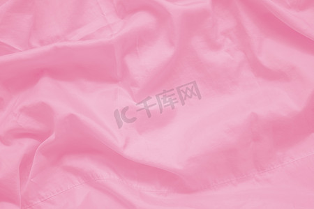 粉色丝滑丝滑摄影照片_背景用纱线织物接缝的抽象皱纹甜粉色织物质地