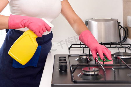 用厨房用具、家居概念或卫生和清洁来清洁燃气灶。