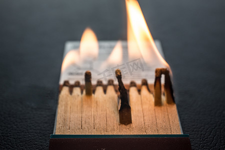 蓝色荧光粉摄影照片_带火柴和火焰的火柴棒字母