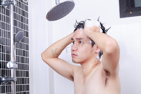 不快乐的男人正在浴室里淋浴和洗头