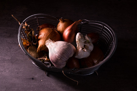 海报饮食摄影照片_旧篮子的海报，上面装有洋葱大蒜西红柿来装饰厨房