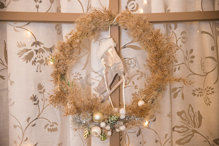 绿色圣诞花环装饰着金色、白色球、灯光和松果，在古老的木板背景上，乡村风格。