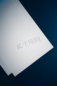 a4背景蓝色摄影照片_空白 A4 纸，蓝色背景白色作为办公文具平铺、豪华品牌平铺和模型的品牌标识设计