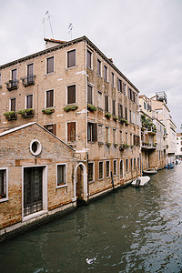 意大利威尼斯运河上一栋建筑物的墙壁上停泊着船只。