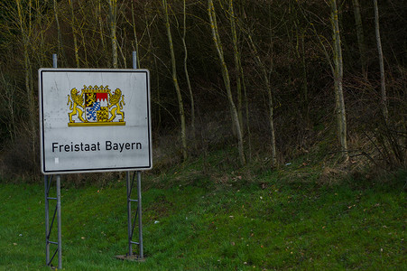 自由摄影照片_带有德国拜仁徽章的白色高速公路边界标志，英文翻译：自由州巴伐利亚