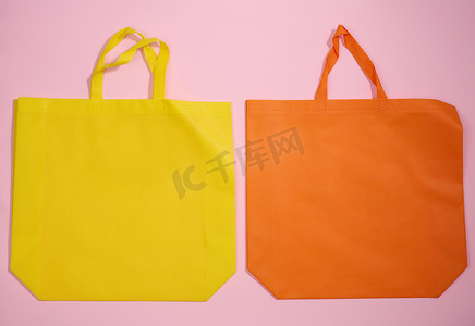 空粘胶环保帆布手提袋，用于粉红色背景上的品牌宣传。