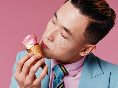 亚洲男人手里拿着冰淇淋，打着蓝色夹克领带