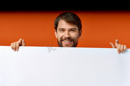 广告海报在一个橙色背景的男人手中，用手做手势复制空间模型