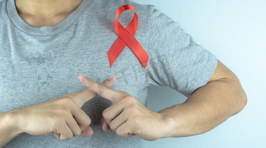 艾滋病红色摄影照片_艾滋病意识，男性手拿着红色的艾滋病意识丝带。