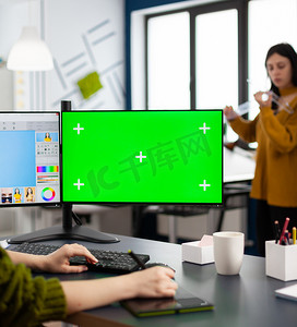 色度摄影照片_在绿色模拟屏幕计算机上工作的摄影师