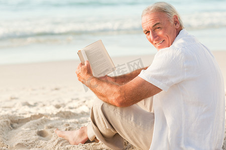 男人在沙滩上看书