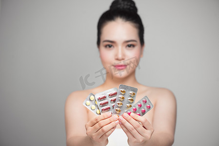 健康快乐的亚洲女人手里拿着药丸。