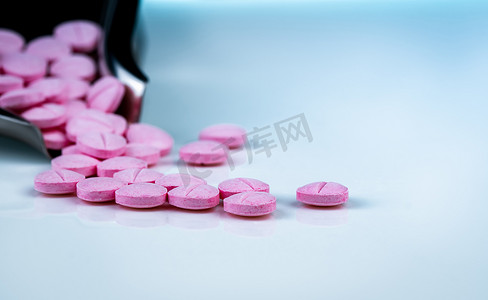 禁忌症摄影照片_药物托盘模糊背景上的粉红色药丸。