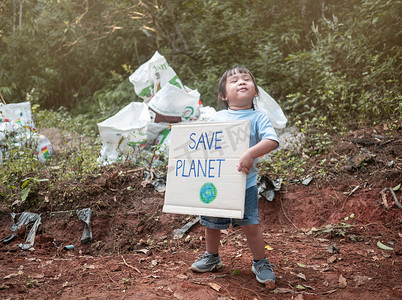 拿着“拯救地球”海报的小女孩展示了抗议森林塑料污染的标志。