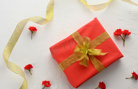 用节日红纸包装的盒子，背景上系着丝带，生日礼物
