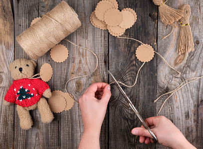女手剪断棕色绳子做标签，玩具制作过程