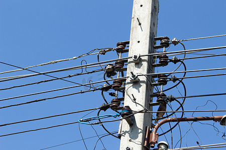 电线杆上杂乱的电缆和电线在清澈的蓝色上
