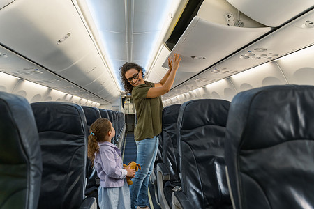 飞行前微笑的成年母亲和孩子站在飞机上