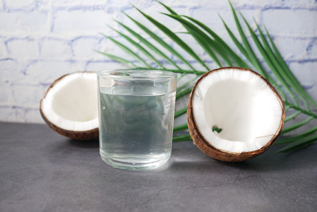 桌上放着一片新鲜椰子和一杯椰子水