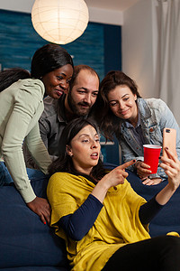 多种族朋友深夜闲逛，在智能手机上观看有趣的娱乐视频