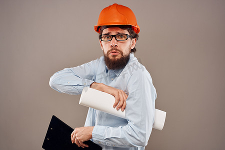 安全施工海报摄影照片_橙色头盔衬衫安全专业服务米色背景的工程师