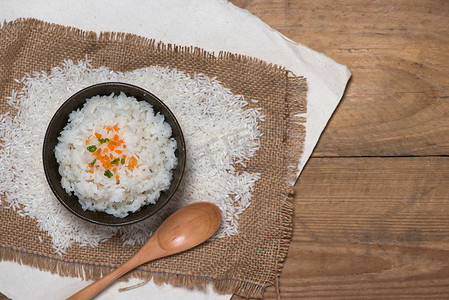 木桌上木碗中煮熟的米饭的特写