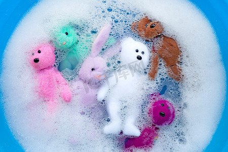 将带熊玩具的兔子娃娃用洗衣液水浸泡