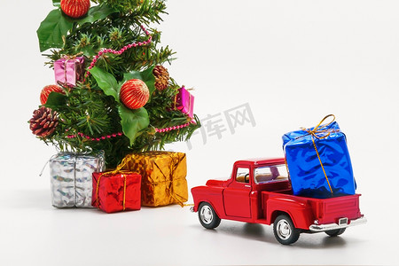 玩具礼物盒摄影照片_红色复古汽车玩具带有一个装有圣诞树礼物的盒子