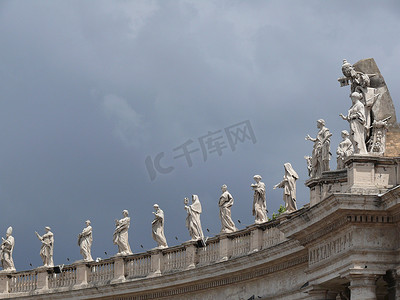 多云的天空笼罩着圣彼得广场柱廊的雕像