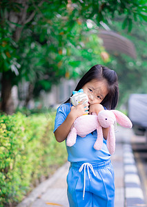公园里有洋娃娃的可爱亚洲小女孩